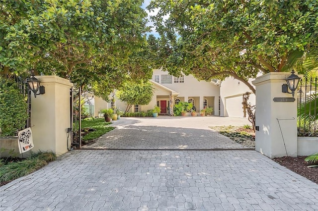 view of front of home with decorative driveway and stucco siding