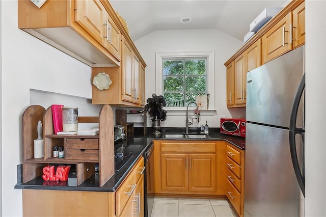 kitchen featuring light tile patterned floors, freestanding refrigerator, a sink, vaulted ceiling, and dishwasher