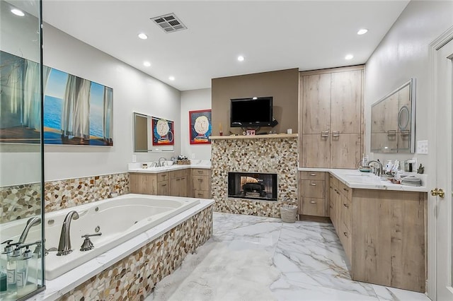 bathroom featuring visible vents, two vanities, a fireplace, a sink, and a jetted tub