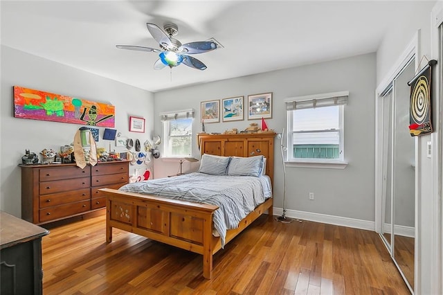 bedroom with a ceiling fan, baseboards, and hardwood / wood-style floors