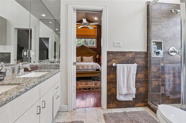 full bathroom with a shower stall, tile walls, toilet, ensuite bath, and vanity