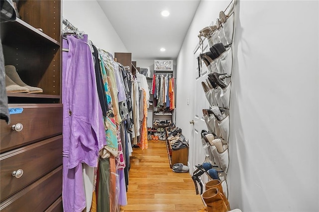 walk in closet with wood finished floors