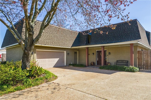 view of front of property featuring driveway, fence, an attached garage, a shingled roof, and brick siding