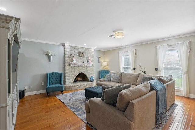 living area featuring light wood-style flooring, a fireplace, and ornamental molding