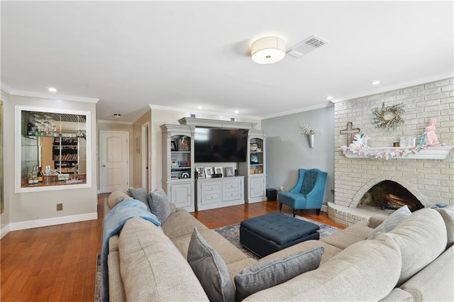 living room with wood finished floors, crown molding, a fireplace, and baseboards