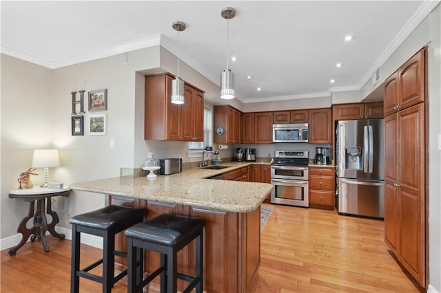 kitchen featuring light wood-style flooring, a sink, stainless steel appliances, a peninsula, and crown molding