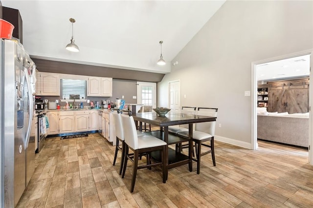 dining area with baseboards, high vaulted ceiling, and light wood-style floors