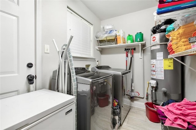 washroom featuring water heater, laundry area, and washing machine and dryer