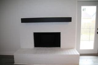 room details featuring a tile fireplace and wood finished floors