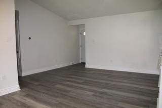 spare room featuring wood finished floors and baseboards