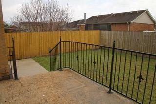 view of gate with a lawn and fence private yard