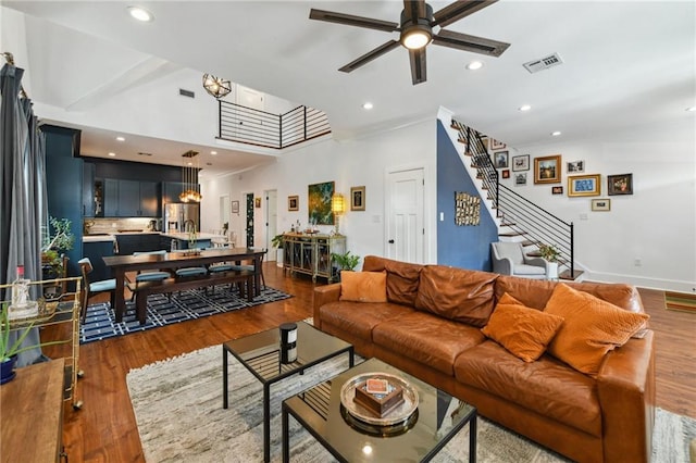 living room with visible vents, wood finished floors, recessed lighting, ceiling fan, and stairs