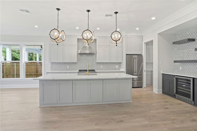 kitchen with visible vents, wine cooler, high quality fridge, wall chimney exhaust hood, and open shelves