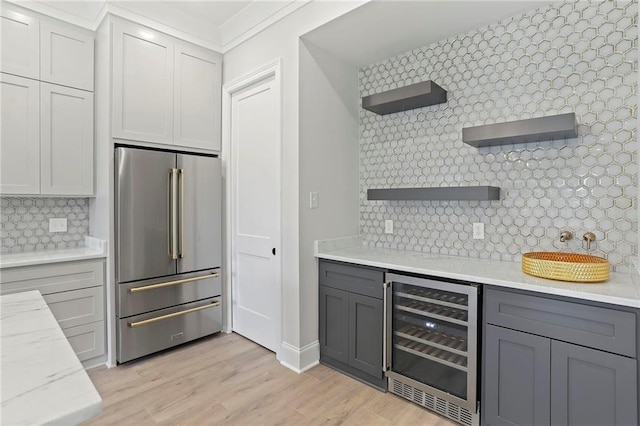 kitchen with tasteful backsplash, beverage cooler, high quality fridge, light wood-style floors, and open shelves