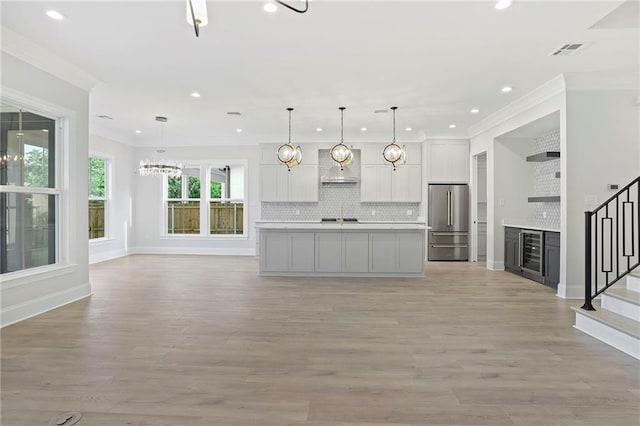 kitchen with visible vents, backsplash, wine cooler, light countertops, and high quality fridge