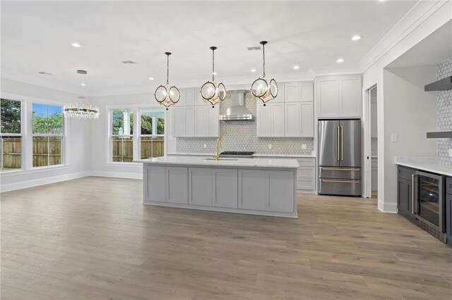 1416 Choctaw Ave, Metairie, LA 70005 - kitchen with light countertops, freestanding refrigerator, a chandelier, and wall chimney exhaust hood