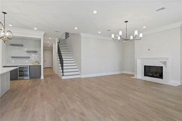 1416 Choctaw Ave, Metairie, LA 70005 - unfurnished living room featuring crown molding, light wood-type flooring, stairway, a notable chandelier, and baseboards