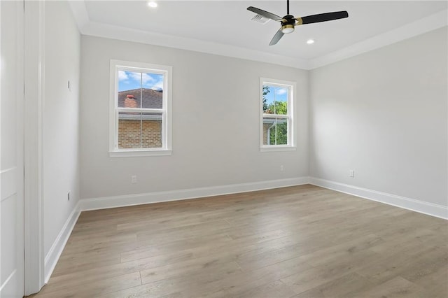 empty room featuring a wealth of natural light, light wood-type flooring, and crown molding