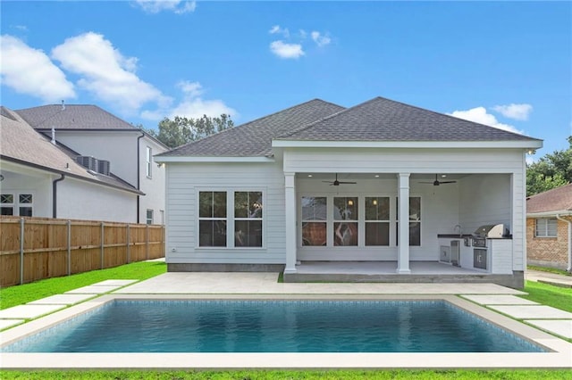 rear view of house featuring a fenced in pool, fence, roof with shingles, a patio, and a ceiling fan