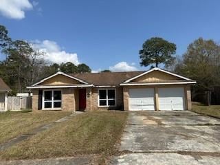 ranch-style house featuring a garage, a front lawn, and driveway