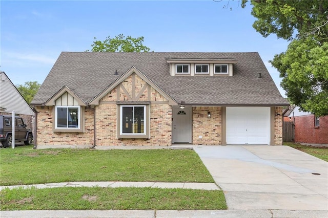 english style home featuring a front yard, driveway, and a shingled roof