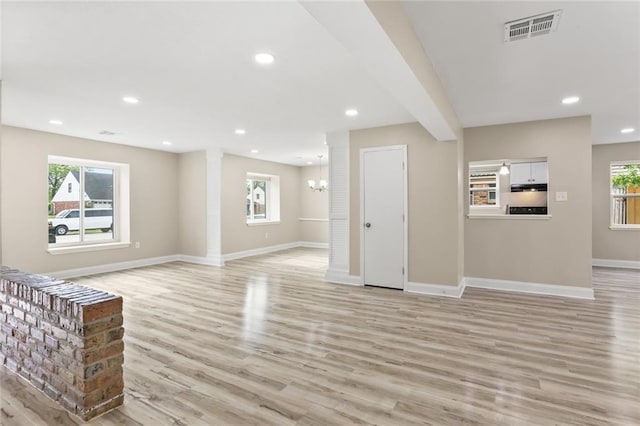 unfurnished living room featuring a wealth of natural light, recessed lighting, visible vents, and light wood finished floors