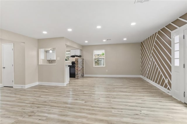 unfurnished living room with recessed lighting, baseboards, and light wood-style flooring