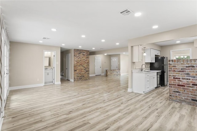 kitchen with light countertops, open floor plan, visible vents, and freestanding refrigerator