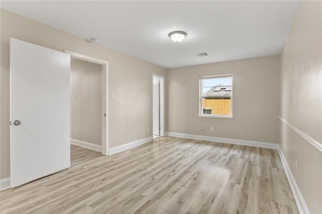 unfurnished room with light wood-style flooring, baseboards, and visible vents