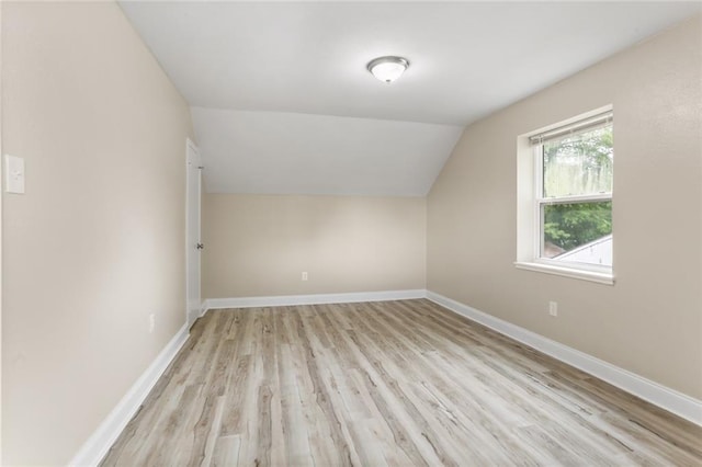 bonus room with lofted ceiling, light wood-style flooring, and baseboards