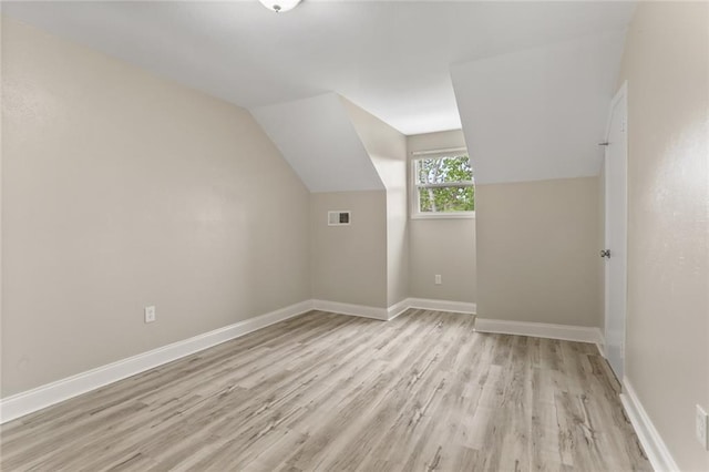 bonus room featuring vaulted ceiling, baseboards, visible vents, and light wood-type flooring