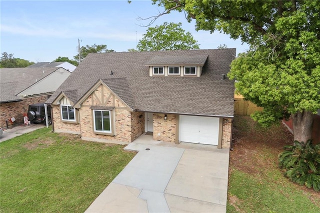 tudor house with a front lawn, driveway, fence, roof with shingles, and a garage