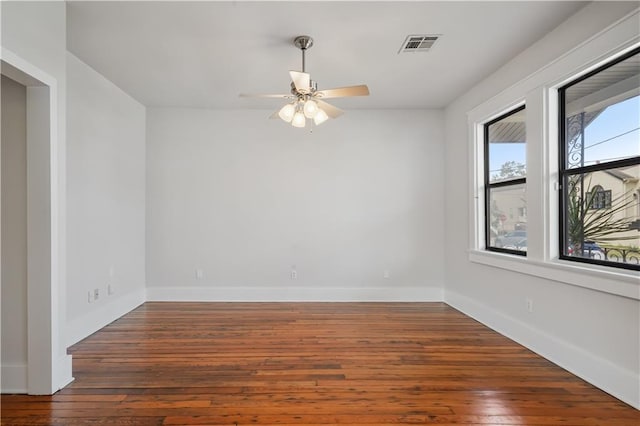 unfurnished room featuring hardwood / wood-style floors, a ceiling fan, and baseboards