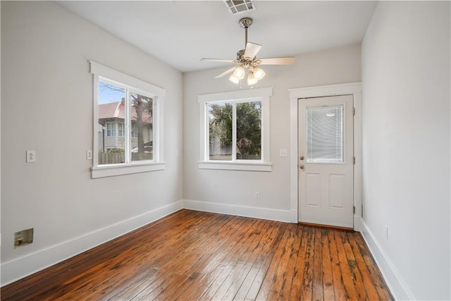 interior space with baseboards, visible vents, wood-type flooring, and ceiling fan