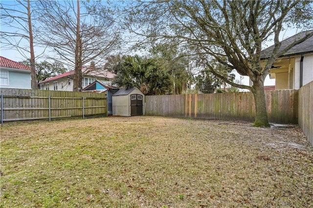 view of yard with an outbuilding, a fenced backyard, and a shed