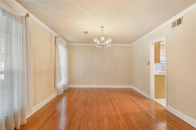 unfurnished room with visible vents, wood finished floors, and ornamental molding