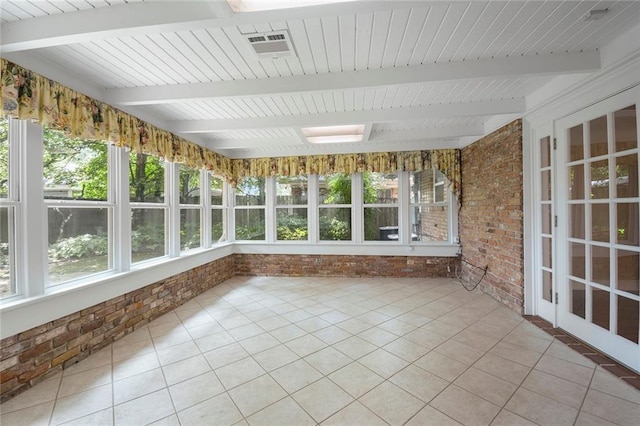 unfurnished sunroom featuring beamed ceiling and plenty of natural light