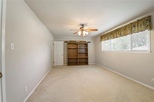 unfurnished room with baseboards, light colored carpet, and ceiling fan