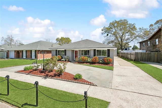 view of front of property with driveway, a front yard, and fence