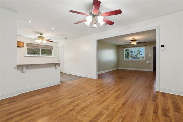 unfurnished living room with recessed lighting, baseboards, wood finished floors, and ceiling fan