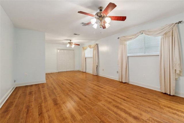 spare room with ceiling fan, visible vents, baseboards, and light wood-style flooring