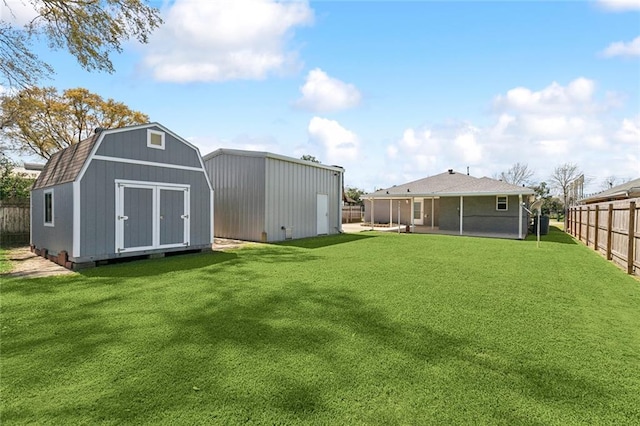 view of yard featuring a storage unit, an outbuilding, and a fenced backyard