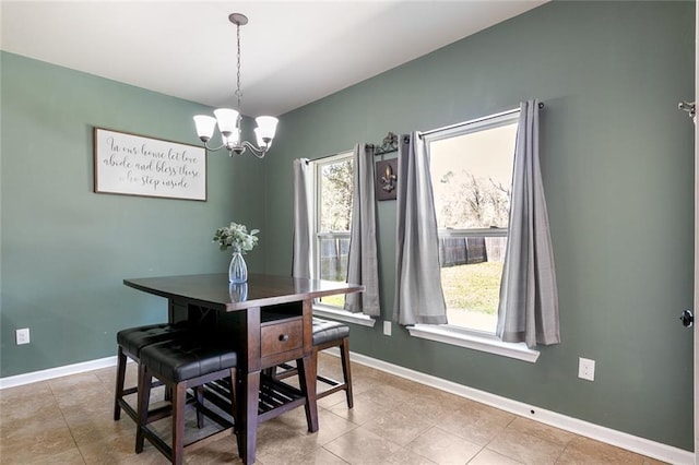 dining space with light tile patterned floors, baseboards, and a notable chandelier