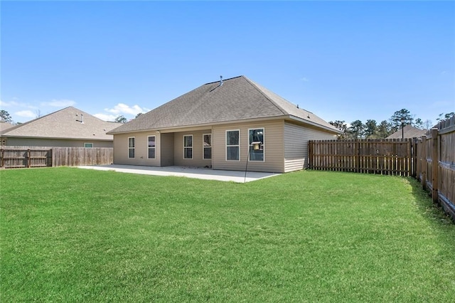 rear view of house featuring a patio, a lawn, a fenced backyard, and a shingled roof