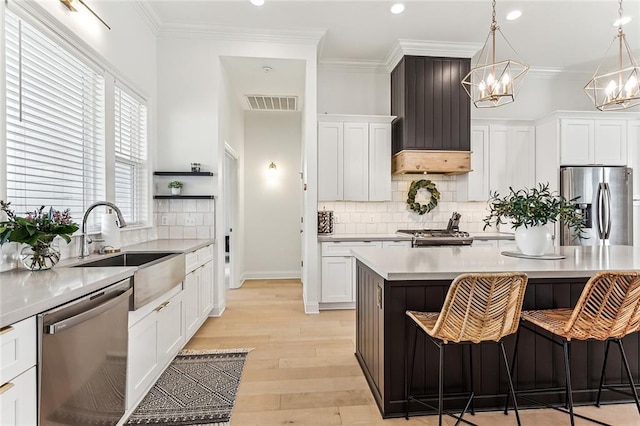 kitchen with visible vents, ornamental molding, stainless steel appliances, and a sink