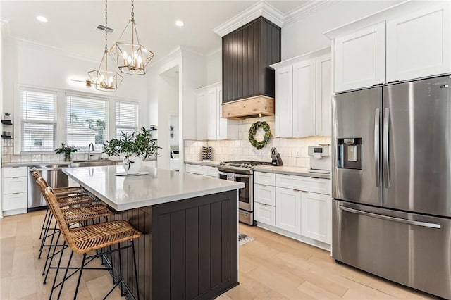 kitchen with visible vents, ornamental molding, a sink, stainless steel appliances, and decorative backsplash