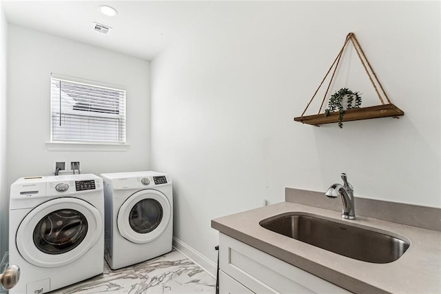 clothes washing area featuring visible vents, marble finish floor, a sink, washing machine and dryer, and cabinet space