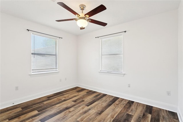 spare room with baseboards, dark wood-style floors, and ceiling fan