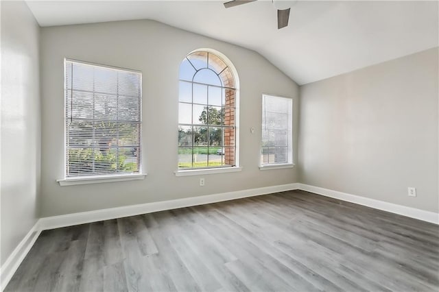 empty room featuring a ceiling fan, lofted ceiling, and dark wood-style floors