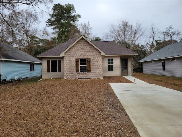 back of house featuring brick siding and a shingled roof